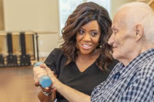 a rehab therapist helping a resident in the rehab gym at the Anchor Post Acute facility